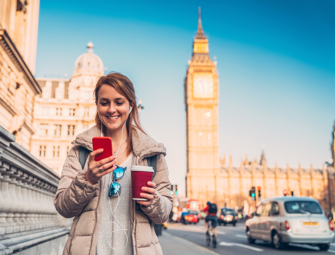 Big Ben çevresinde müzik dinleyerek gezen kadın